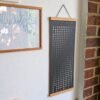 Moon Phase Lunar Calendar – Shadow Edition hanging on wall with teak magnetic poster frame, modern minimalist home décor.
