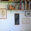 Hanging Moon Phase Lunar Calendar Print on a household interior with a bookcase and other art