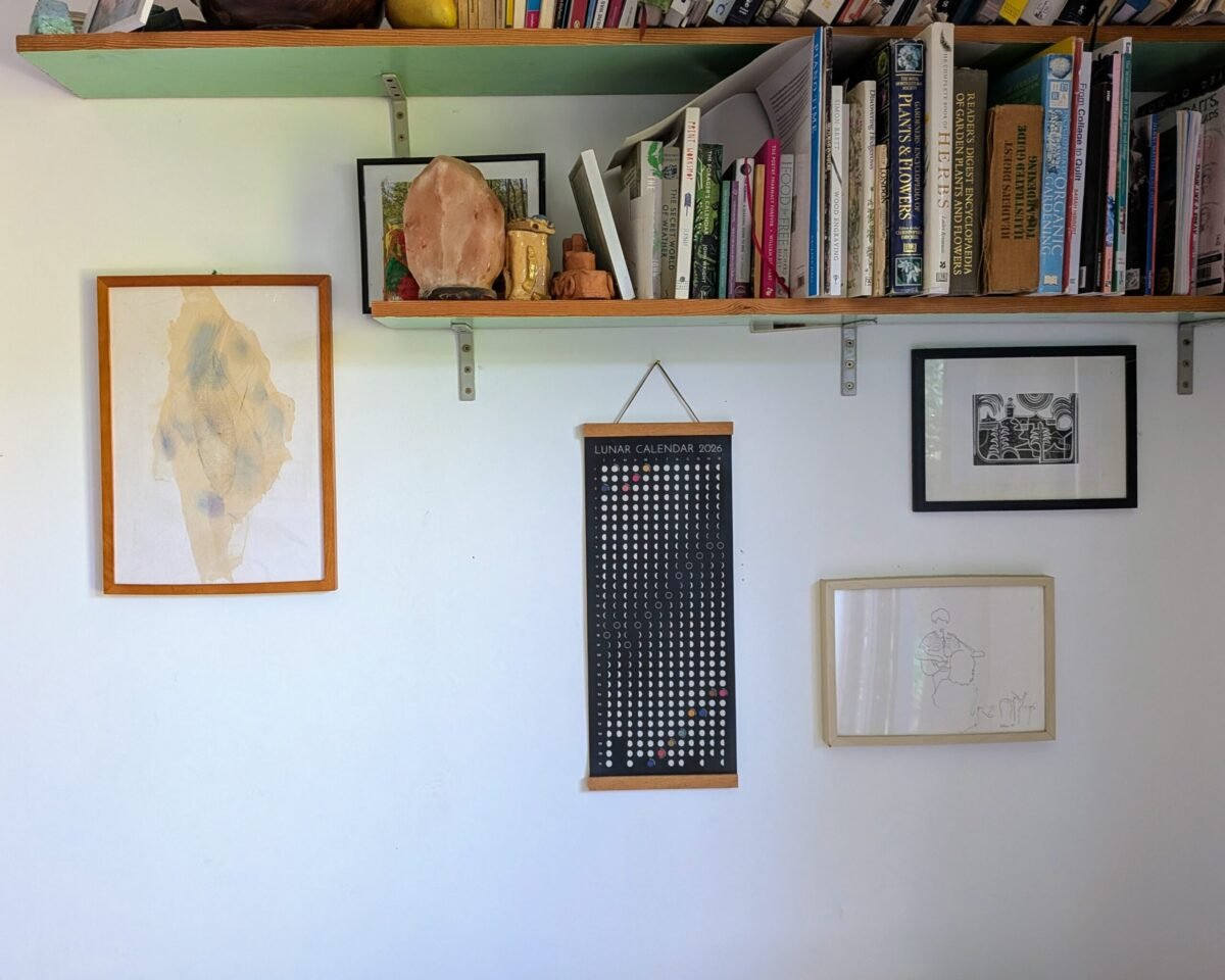 Moonatics | Lunar Calendar 2026 in household interior Hanging Moon Phase Lunar Calendar Print on a household interior with a bookcase and other art