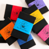 Assortment of Moonatics Eco Potion Kits with colourful paper belly bands in blue, orange, yellow, red, pink, purple and green, arranged in an overlapping flat lay on a white background.