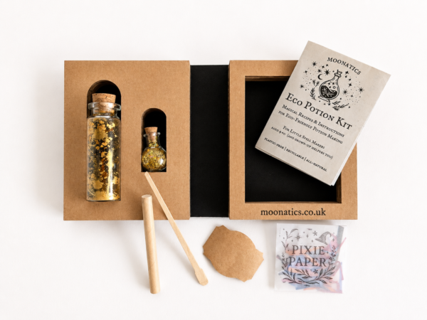 Open mini Moonatics Eco Potion Kit with two glass potion bottles, illustrated instruction booklet and wooden stirring stick, presented in a plastic-free cardboard gift box.